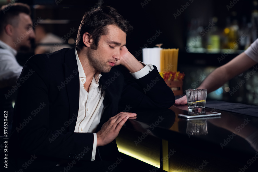a tired man fell asleep at the bar in a restaurant. a tired man fell asleep at the bar in a restaurant.