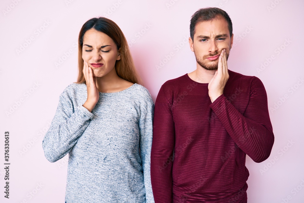 Beautiful couple wearing casual clothes touching mouth with hand with painful expression because of toothache or dental illness on teeth. dentist Beautiful couple wearing casual clothes touching mouth with hand with painful expression because of toothache or dental illness on teeth. dentist