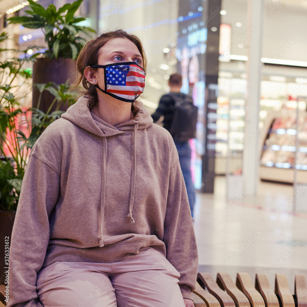 Portrait of a woman with a medical mask on her face in the form of a flag of america Portrait of a woman with a medical mask on her face in the form of a flag of america
