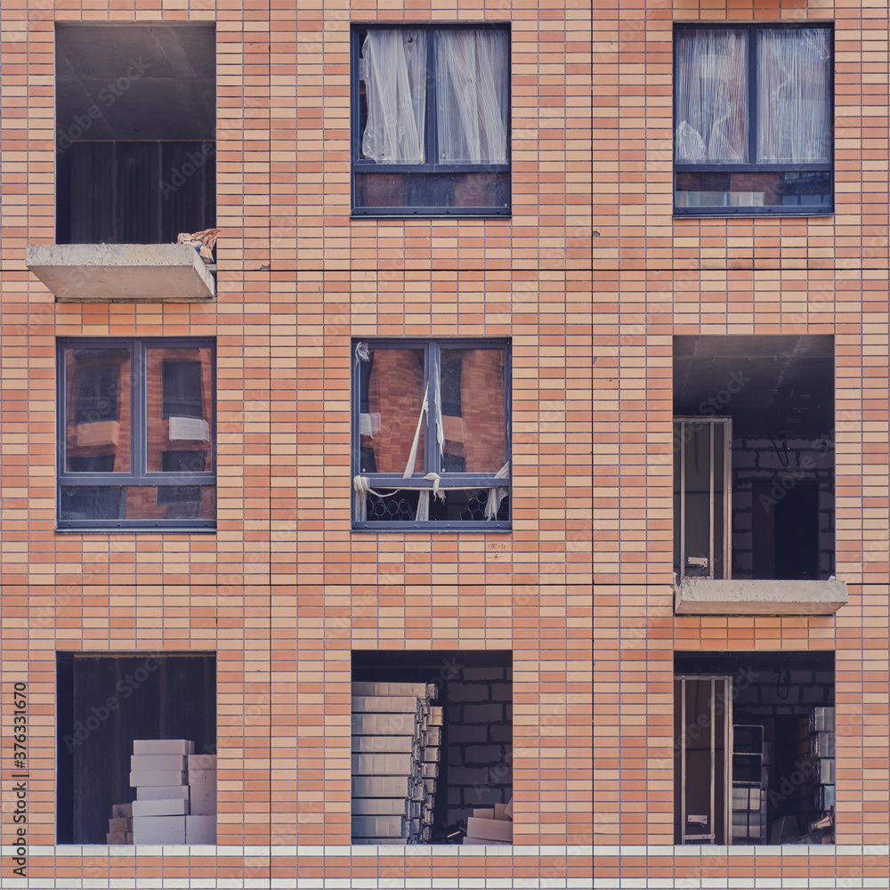 Fototapeta premium Facade with windows of an unfinished building, closeup house