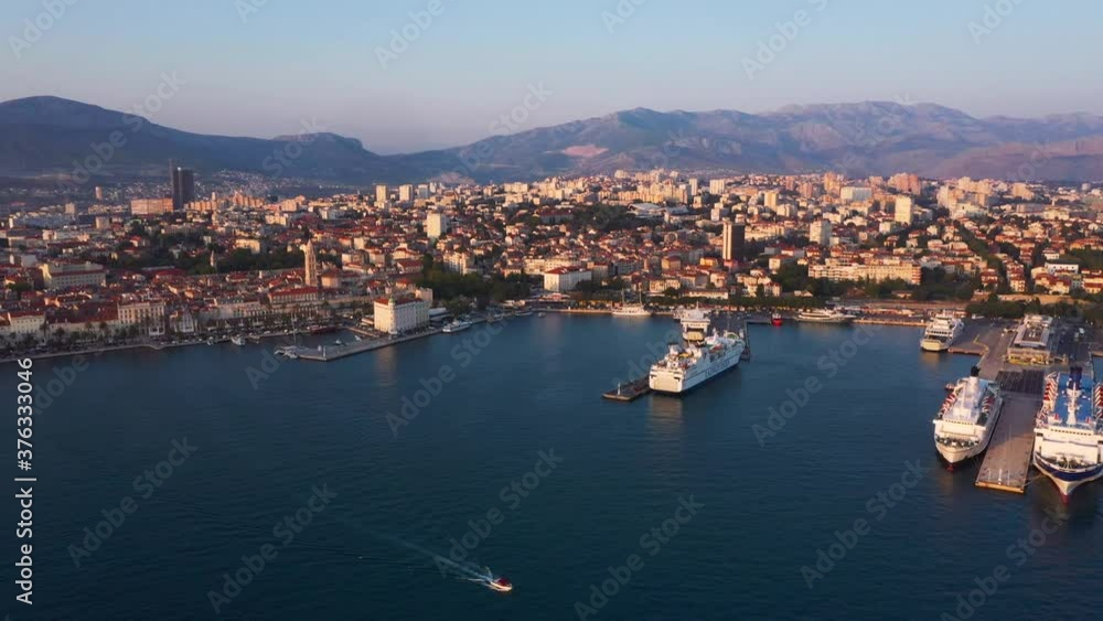 Reveal drone during sunset of Split in Croatia with city and sea infront and mountains in the background in 4k flying backwards. Reveal drone during sunset of Split in Croatia with city and sea infront and mountains in the background in 4k flying backwards.