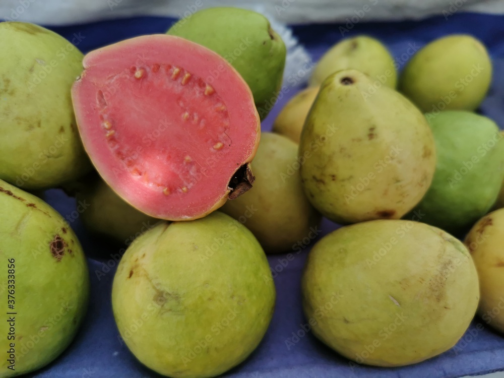Photo of guavas with one of them cut in half at a street market