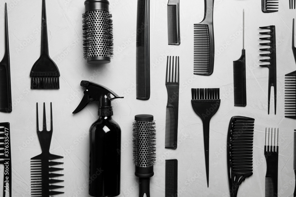 Flat lay composition with hair brushes and combs on light grey stone background Flat lay composition with hair brushes and combs on light grey stone background