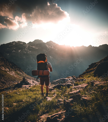 Man traveler hiking alone in breathtaking landscape of austrian Mounatins at sunset. Travel Lifestyle wanderlust adventure concept. Outdoor wilderness vacations. photo