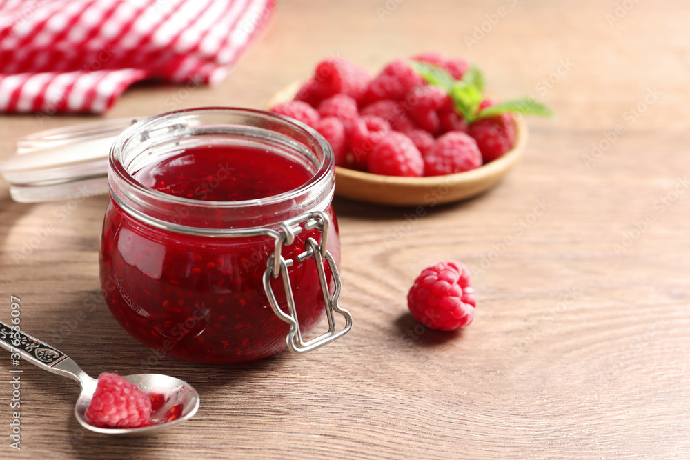Sweet raspberry jam and fresh berries on wooden table Sweet raspberry jam and fresh berries on wooden table