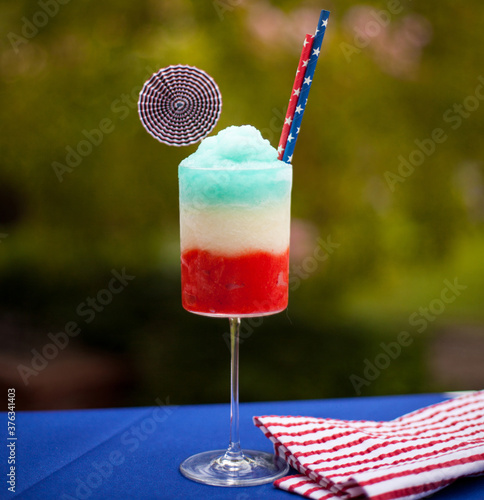 red, white and blue patriotic frozen cocktail, stemmed glass, outdoors, straws