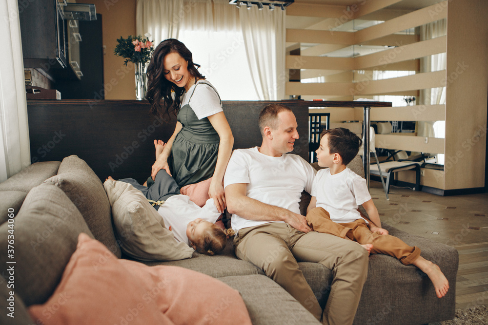 A family with two children is sitting on the sofa. Weekend at home. Spending time together A family with two children is sitting on the sofa. Weekend at home. Spending time together