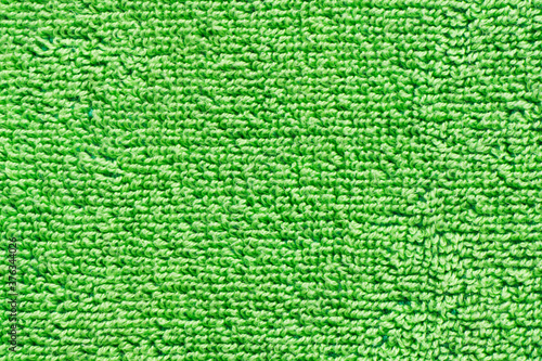 Green towel texture. Macro fiber pattern. Soft cotton textile material background. Absorbent fluffy cloth.