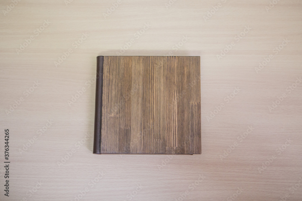 Diary close-up on a beige background. the cover is made of wood. the best gift - a photo album