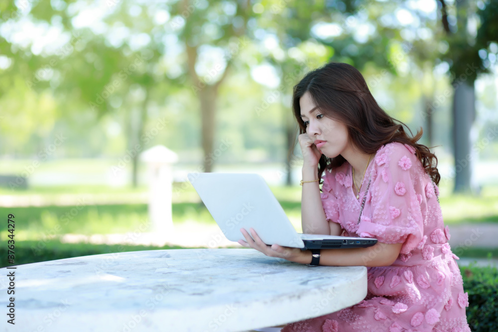 A beautiful woman sitting in the park working Clearing out the tasks that were not ordered as needed. A beautiful woman sitting in the park working Clearing out the tasks that were not ordered as needed.