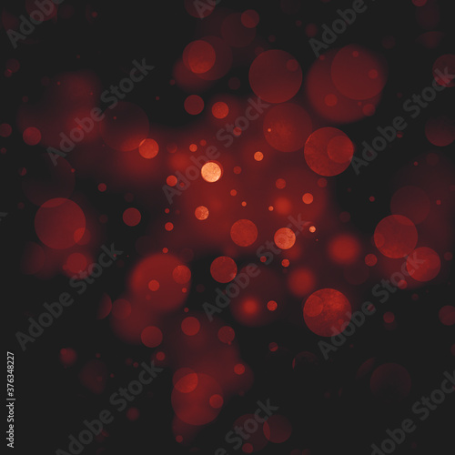 red Christmas bokeh lights shining on black background, abstract red circles with texture in abstract holiday sky of blurred white and red lights