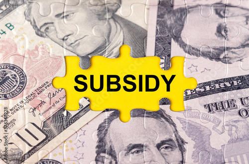 Puzzle with the image of dollars in the center of the inscription -SUBSIDY