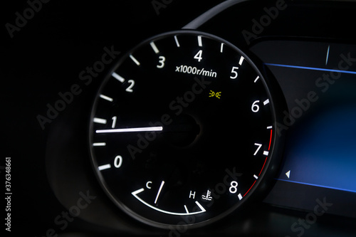 dashboard of the car is illuminated by bright circle tachometer.