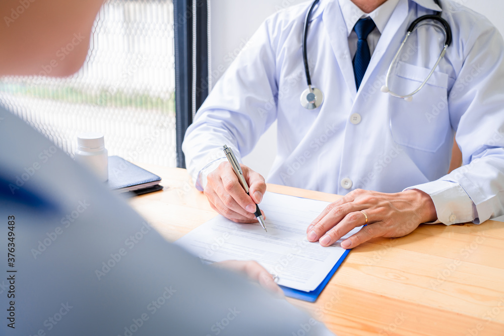 Charming Asian male doctor giving advice and medical informations and diagnosis to a female patient at consulting room in clinic. Charming Asian male doctor giving advice and medical informations and diagnosis to a female patient at consulting room in clinic.
