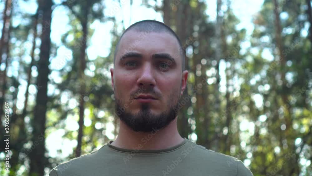 Serious Bearded Man Looks at the Camera. Portrait Attractive Short Haired Man On Forest Background. Piercing Look, Cinematic Emotions. Serious Bearded Man Looks at the Camera. Portrait Attractive Short Haired Man On Forest Background. Piercing Look, Cinematic Emotions.