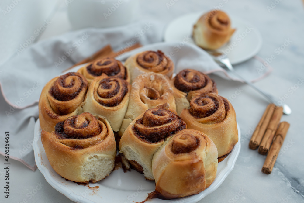Cinnamon rolls with sugar frosting. With cinnamon sticks and spices, wooden background Cinnamon rolls with sugar frosting. With cinnamon sticks and spices, wooden background