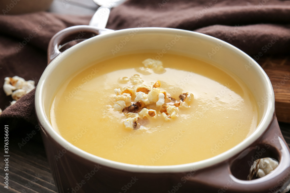 Pot with tasty popcorn soup on table, closeup Pot with tasty popcorn soup on table, closeup