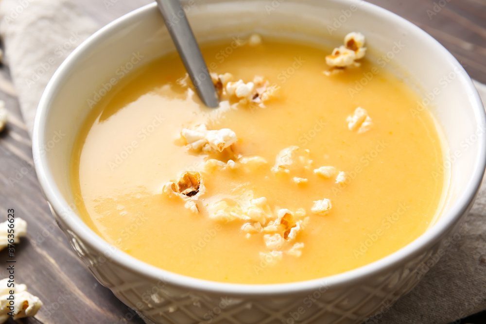 Bowl with tasty popcorn soup on table, closeup Bowl with tasty popcorn soup on table, closeup