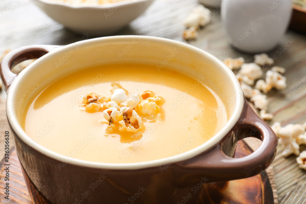 Pot with tasty popcorn soup on table, closeup Pot with tasty popcorn soup on table, closeup