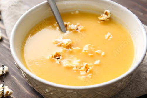 Bowl with tasty popcorn soup on table, closeup