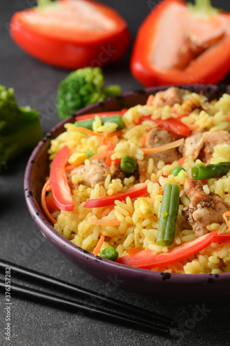 Bowl with tasty fried rice on dark background, closeup