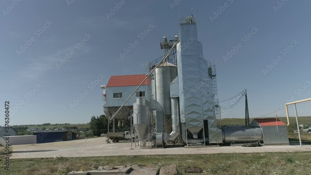 drone from a height flies around a grain dryer on an agricultural farmstead drone from a height flies around a grain dryer on an agricultural farmstead