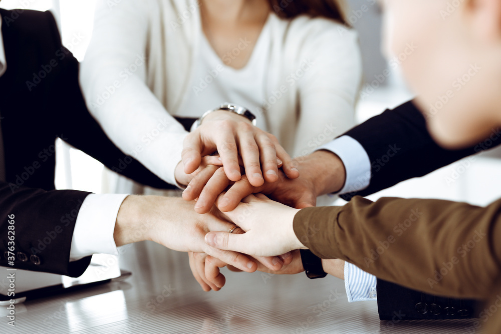 Business people group showing teamwork and joining hands or giving five in modern office. Unknown businessman and women making circle with their hands Business people group showing teamwork and joining hands or giving five in modern office. Unknown businessman and women making circle with their hands