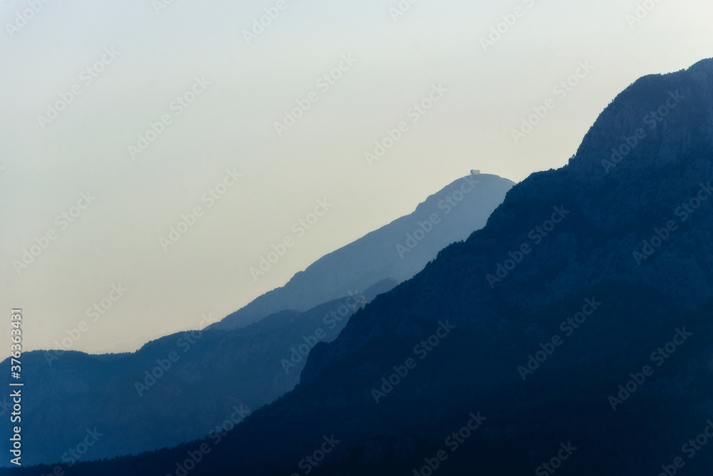 Obraz premium Beautiful landscape of blue mountains layers during sunset