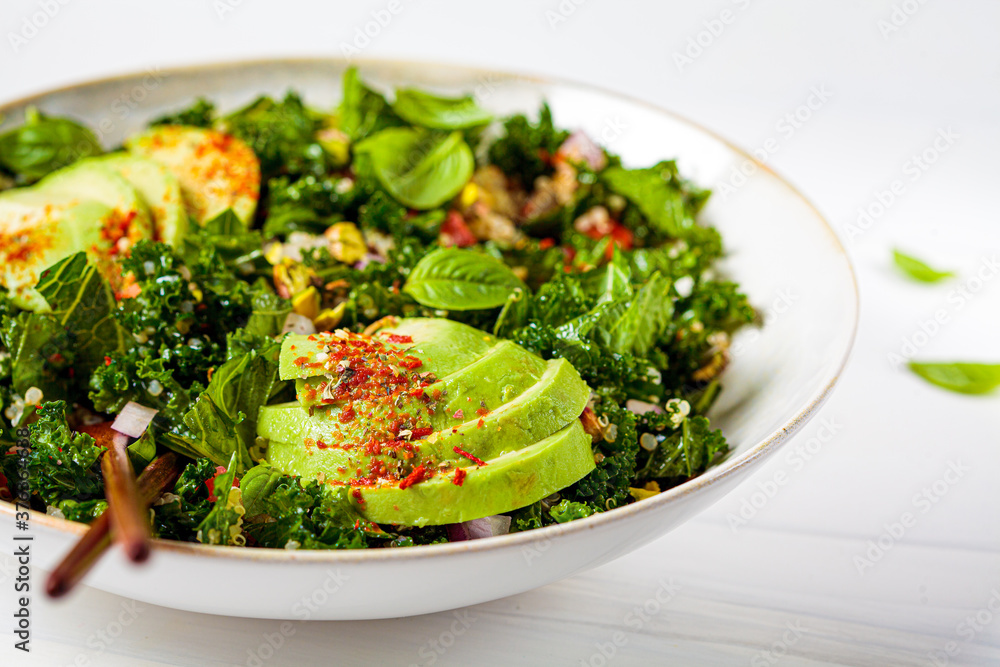 Healthy salad with kale, quinoa, nuts and avocado in white bowl. Healthy vegan food concept. Healthy salad with kale, quinoa, nuts and avocado in white bowl. Healthy vegan food concept.
