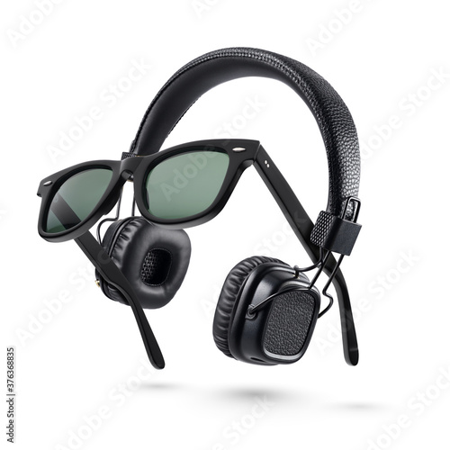 Wireless black headphones and plastic sunglasses isolated on white