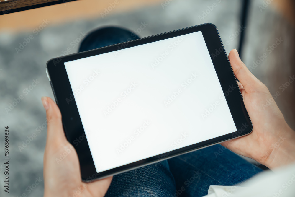 Closeup of woman hand holding digital tablet on the table and the screen is blank. Closeup of woman hand holding digital tablet on the table and the screen is blank.