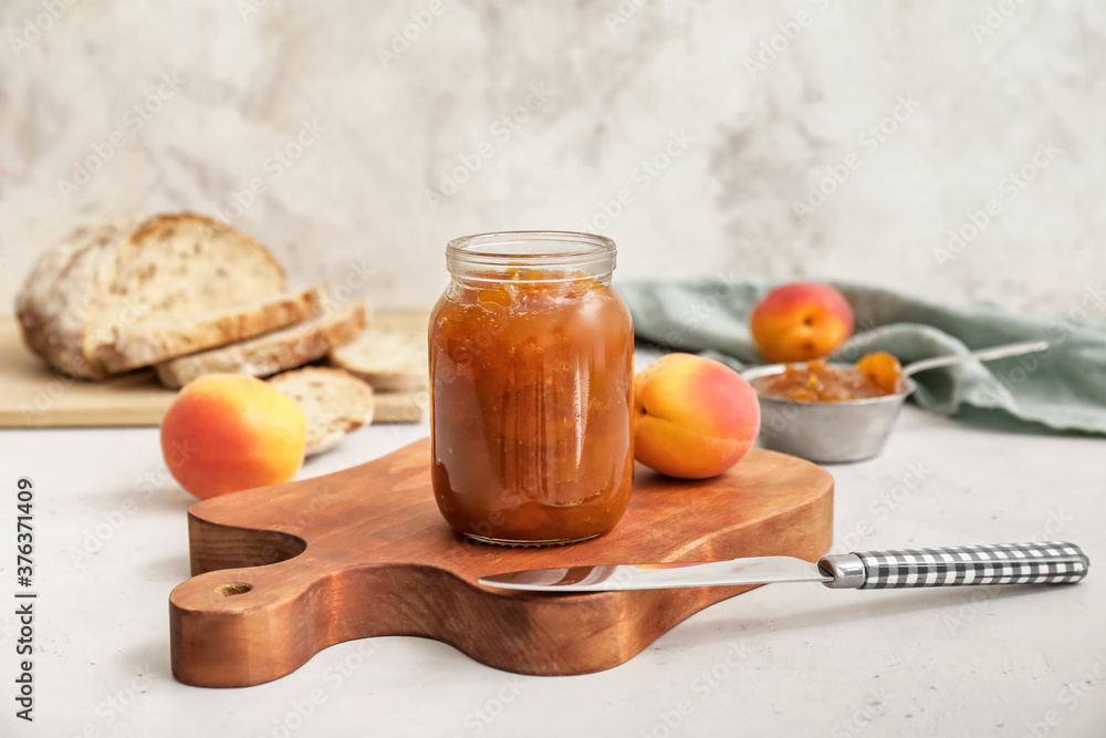 Jar of tasty apricot jam on table Jar of tasty apricot jam on table