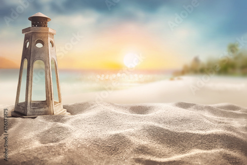 Exotic sandy beach with light house wood lamp deccorate against blur palms trees and beautiful sea with at sunset Summer background concept