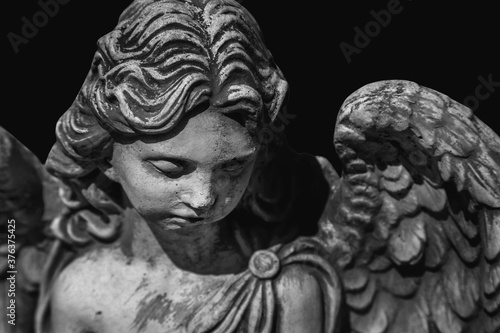 Death. Portrait of sad angel as symbol of pain, fear and end of life. Gragment of an ancient stone statue.