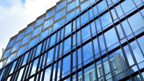 Office building, blue glass wall reflection detail. Modern office building and clear sky background. 