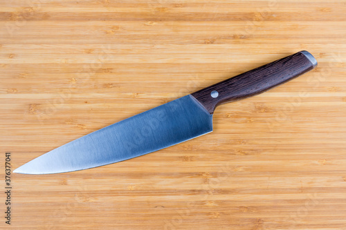 Kitchen large chef's knife on the wooden cutting board
