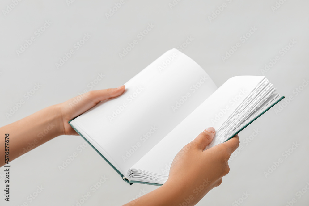 Hands with open book on light background Hands with open book on light background