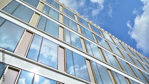 Office building, blue glass wall reflection detail. Modern office building and clear sky background. 