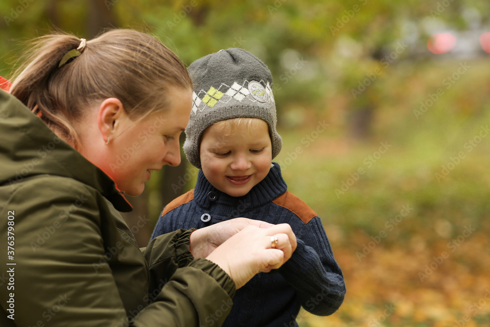 Mother and son in autumn park outdoor. Mom is care of her son. Famity activity in nature Mother and son in autumn park outdoor. Mom is care of her son. Famity activity in nature
