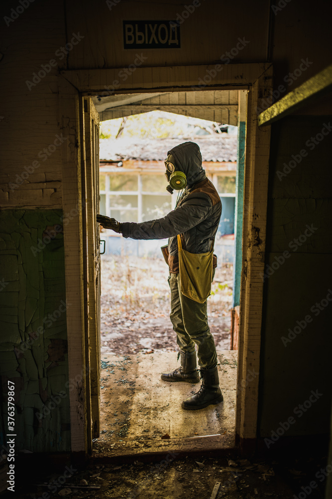Fototapeta premium cosplay on a Stalker, a man in a gas mask stands with a machine gun