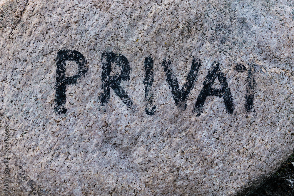 Bright granite erratic block with the faded inscription private to mark the end of the public area Bright granite erratic block with the faded inscription private to mark the end of the public area