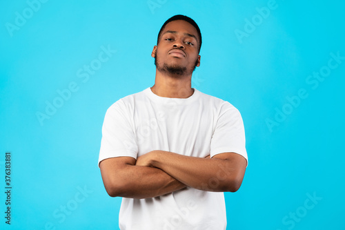 Cool Black Man Standing Crossing Hands Posing On Blue Background