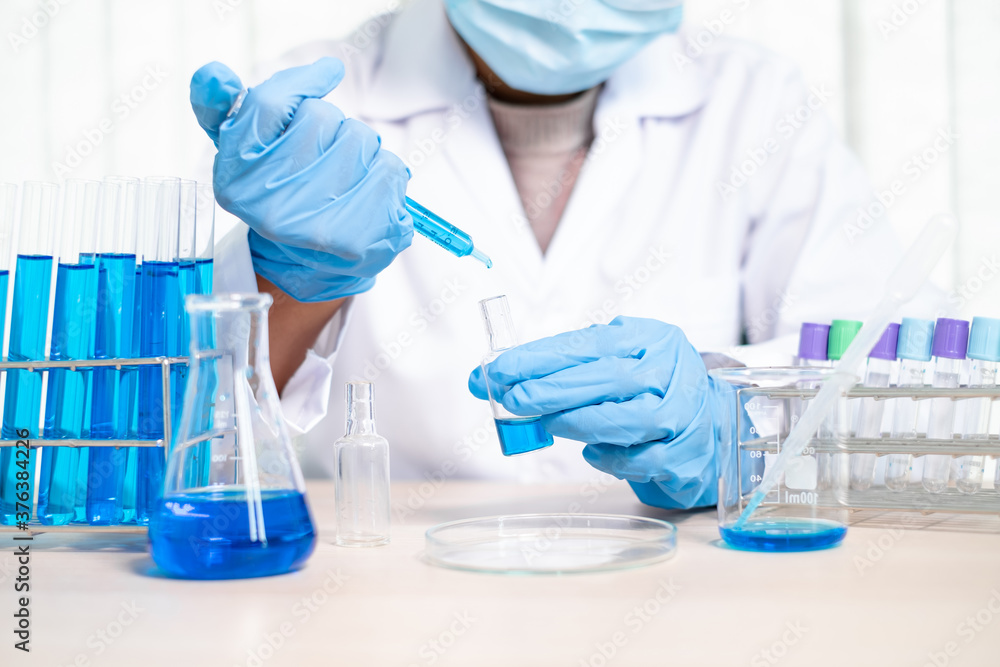 Fototapeta premium Medical scientists released a sample pipetted into a test flask to analyze the virus in a chemical laboratory. Scientific research concepts
