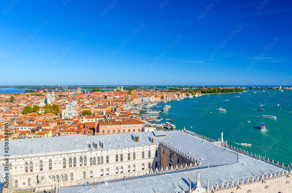 Aerial panoramic view of Venice city historical centre with old buildings red tiled roofs, Doge palace and embankment of Venetian Lagoon, Veneto Region, Northern Italy. Amazing Venice cityscape.