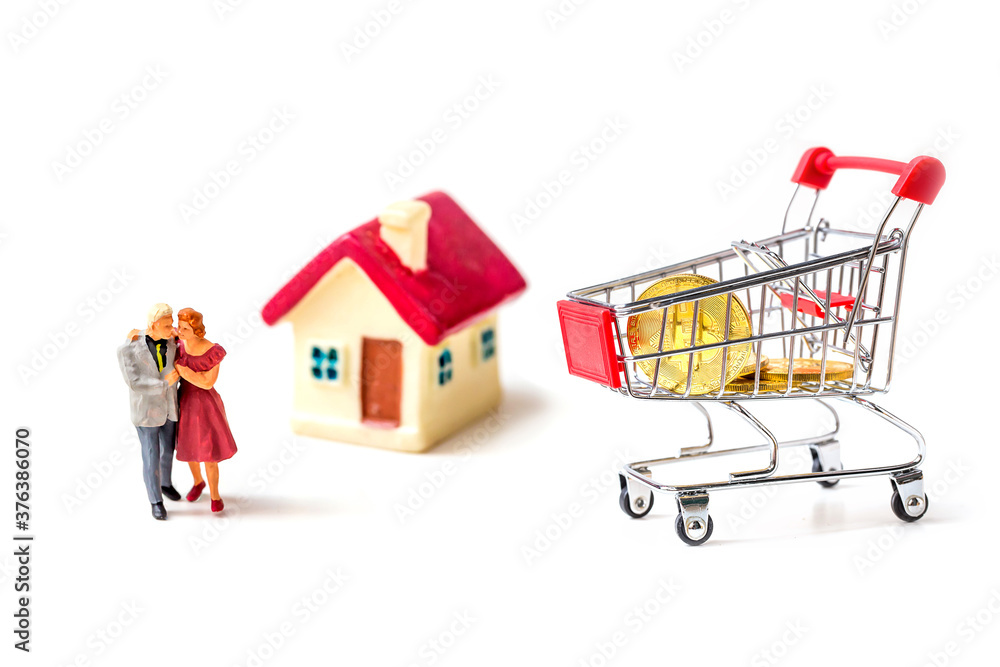 miniature couple with tiny home and piggy bank isolated on white background.