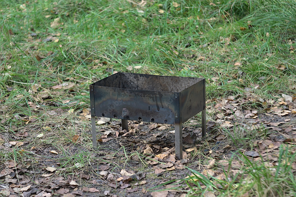 a small barbecue was left in a forest clearing a small barbecue was left in a forest clearing