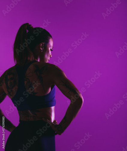 Monochrome portrait of fit woman on purple background
