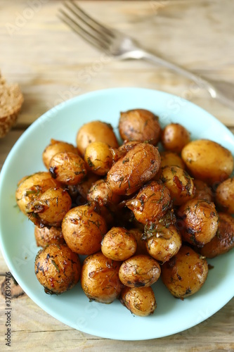 Selective focus. Macro. Fried potatoes in their skins on a plate. Rustic potatoes.