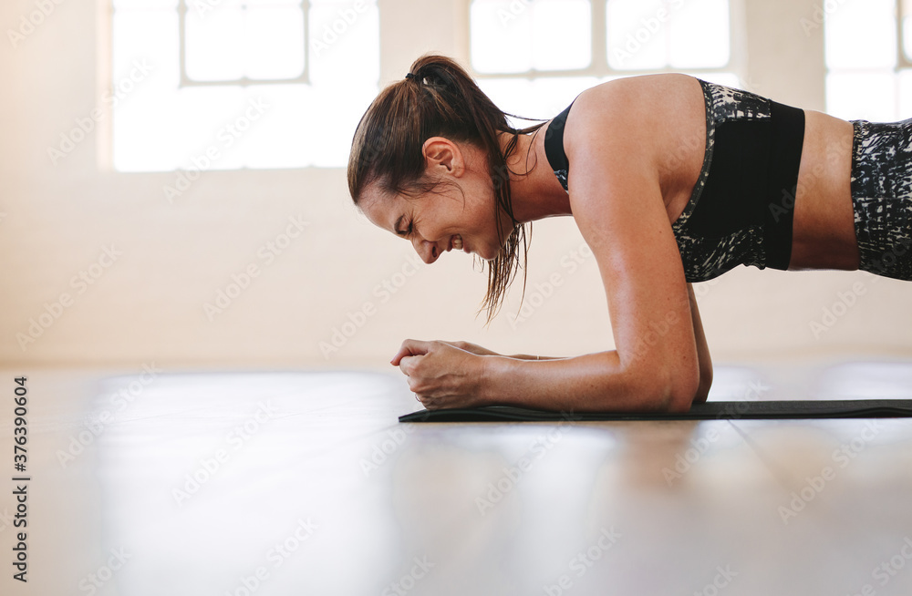 Woman pushing through a painful plank Woman pushing through a painful plank