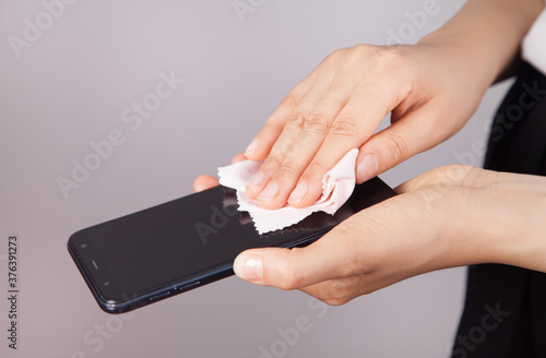 Woman cleaning mobile phone screen.